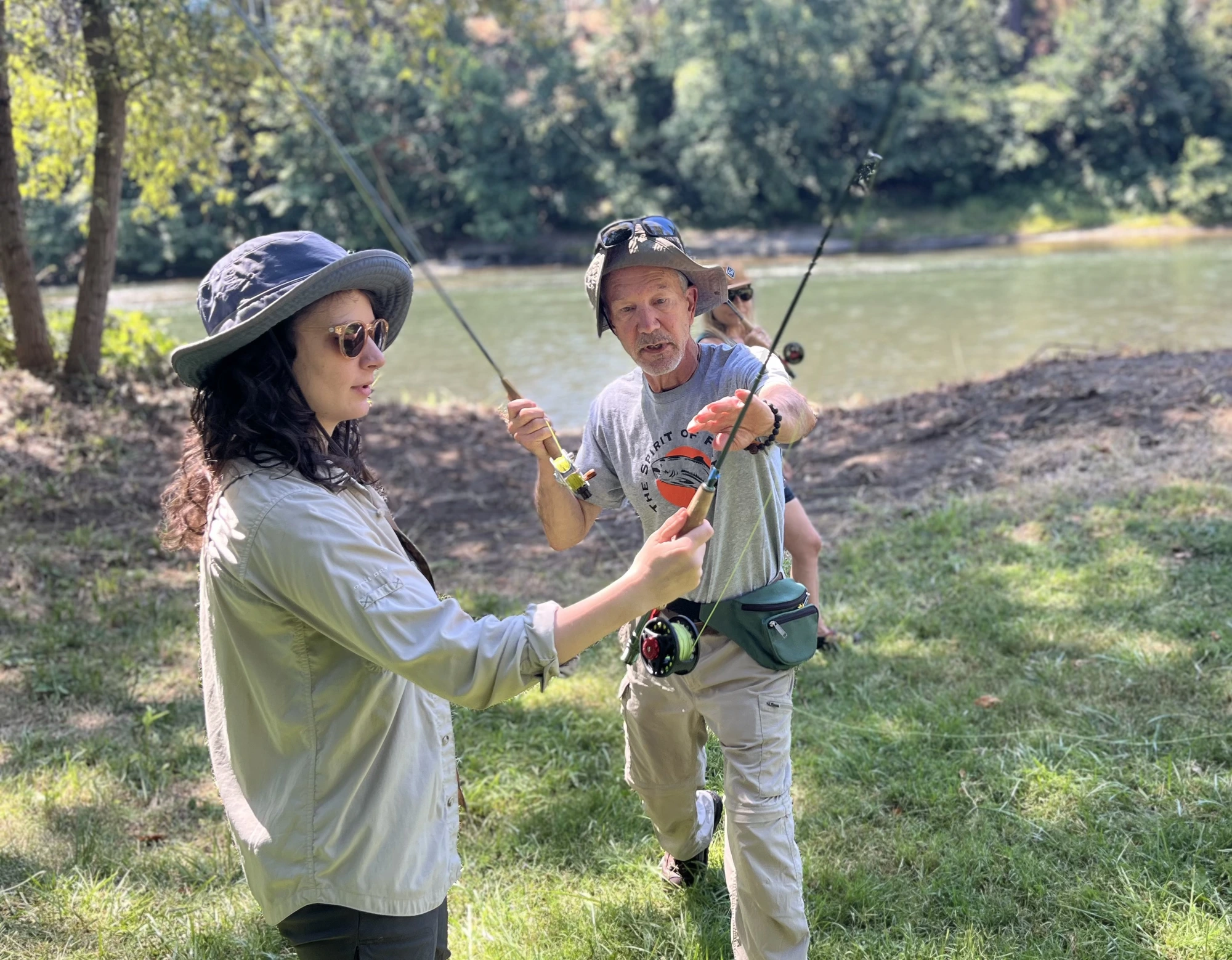 Student and Mike casting side by side on the riverbank